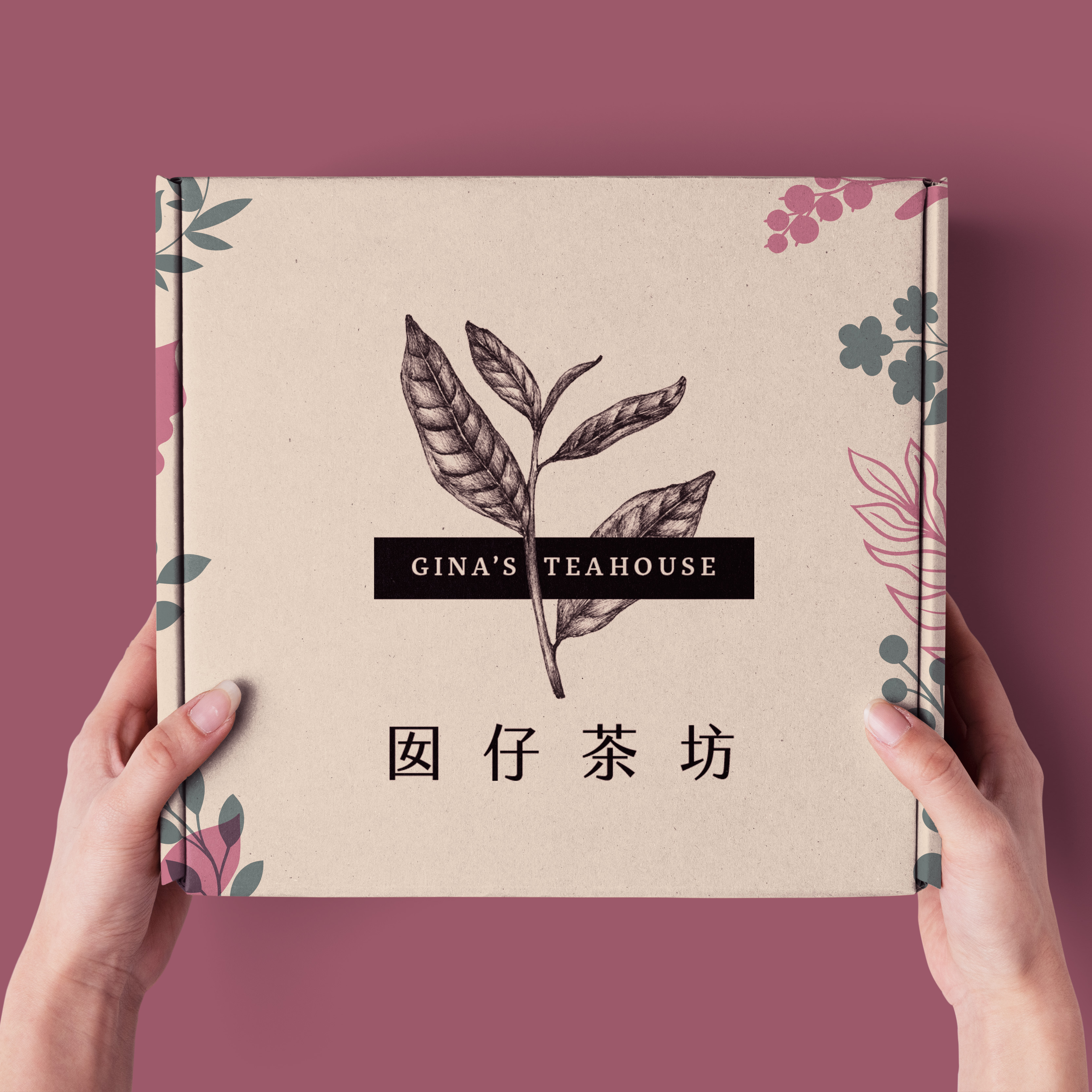 A mockup of a person holding a gift box. The top is printed with the logo and colorful florals.